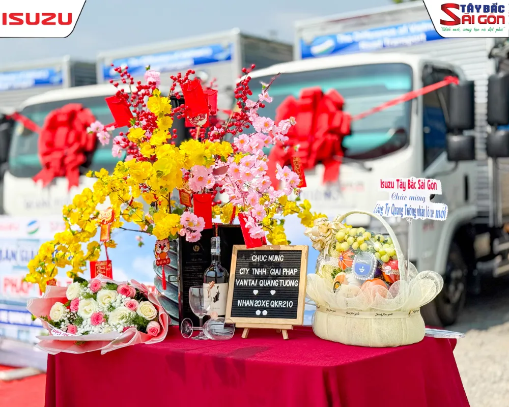 Bàn tiệc hoa và bảng chúc mừng Công ty TNHH Giải pháp Vận tải Quang Tường nhận 20 xe Isuzu QKR210