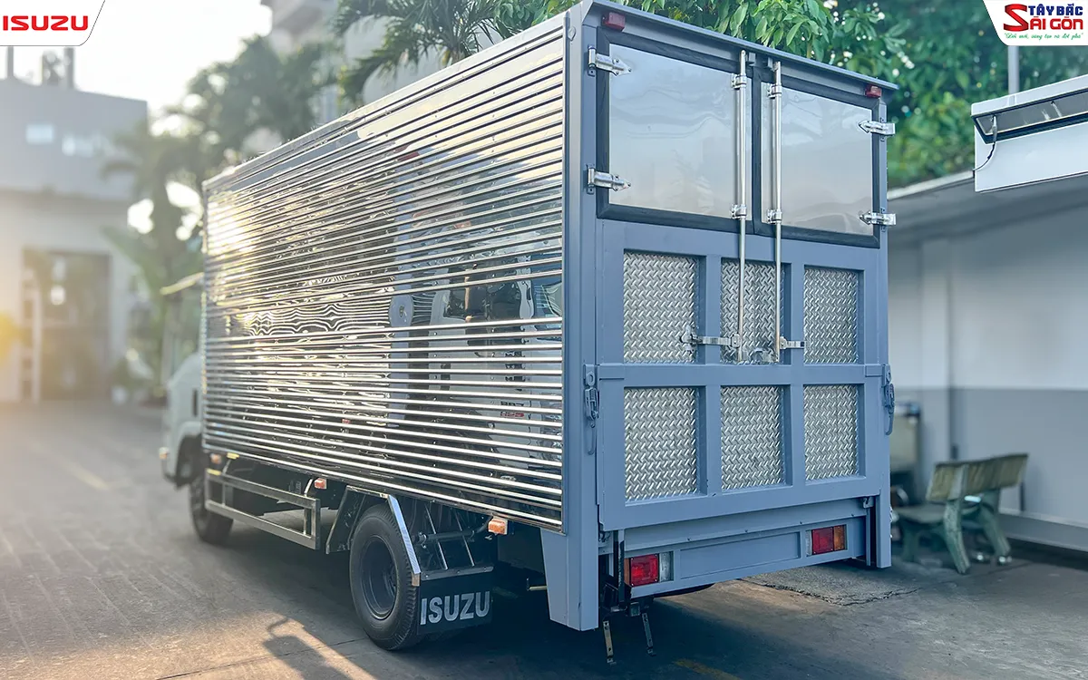 Phía sau thùng kín nhìn chéo: cửa sau hai cánh phía trên, phần dưới ốp tấm lá me trong khung xám