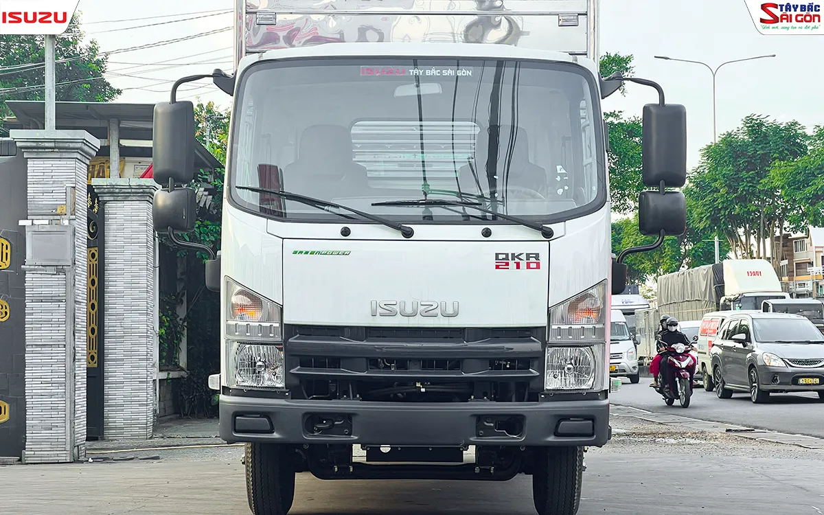 Đầu xe nhìn thẳng từ phía trước: đèn trước, lưới tản nhiệt, logo ISUZU và gương chiếu hậu lớn