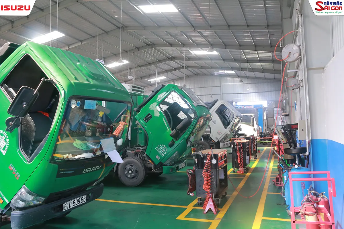 Bên trong xưởng dịch vụ ISUZU với các cabin xe tải được lật lên để sửa chữa