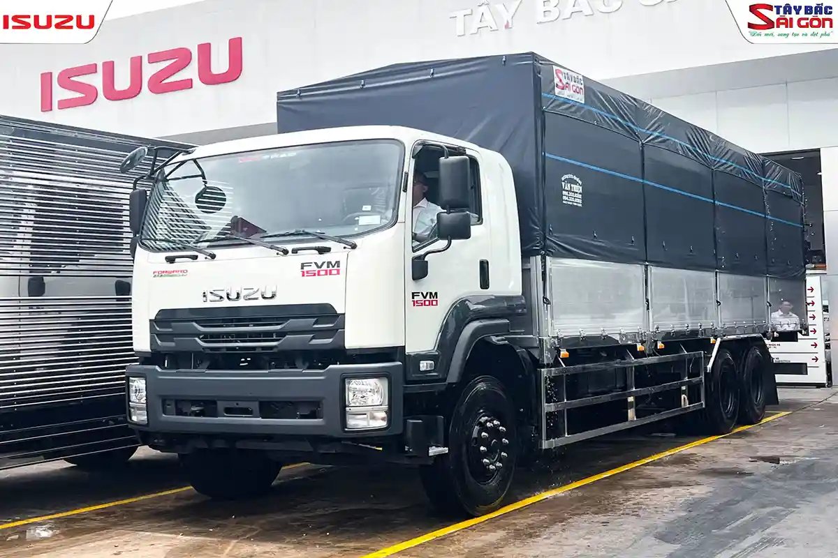 Xe tải ISUZU FVM thùng mui bạt đỗ trước biển hiệu ISUZU